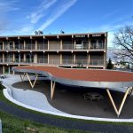 Holzpavillons der Schule Obermatt in Hergiswil mit bestehendem Schulgebäude im Hintergrund